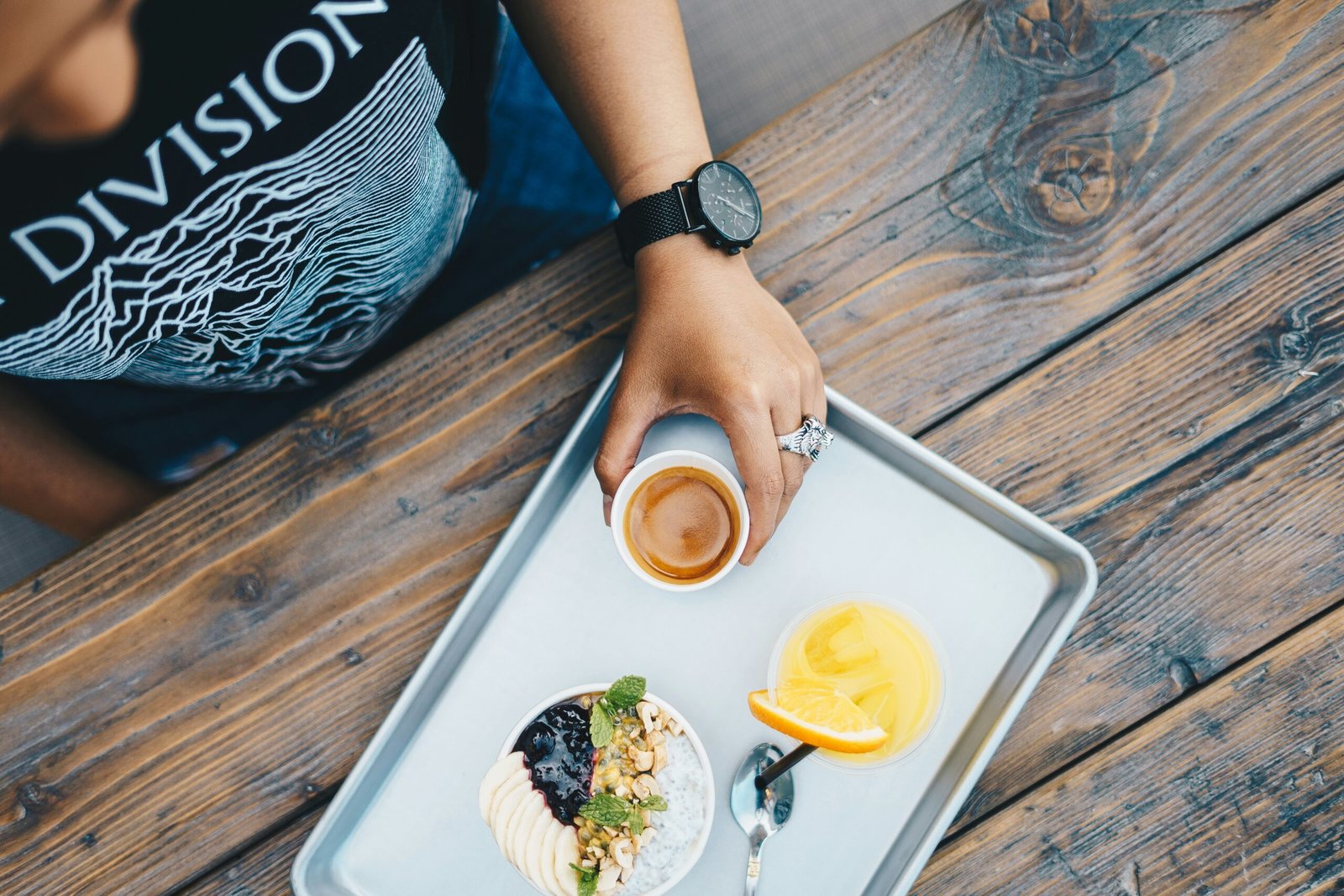 a person holding a cup of tea and a plate of food